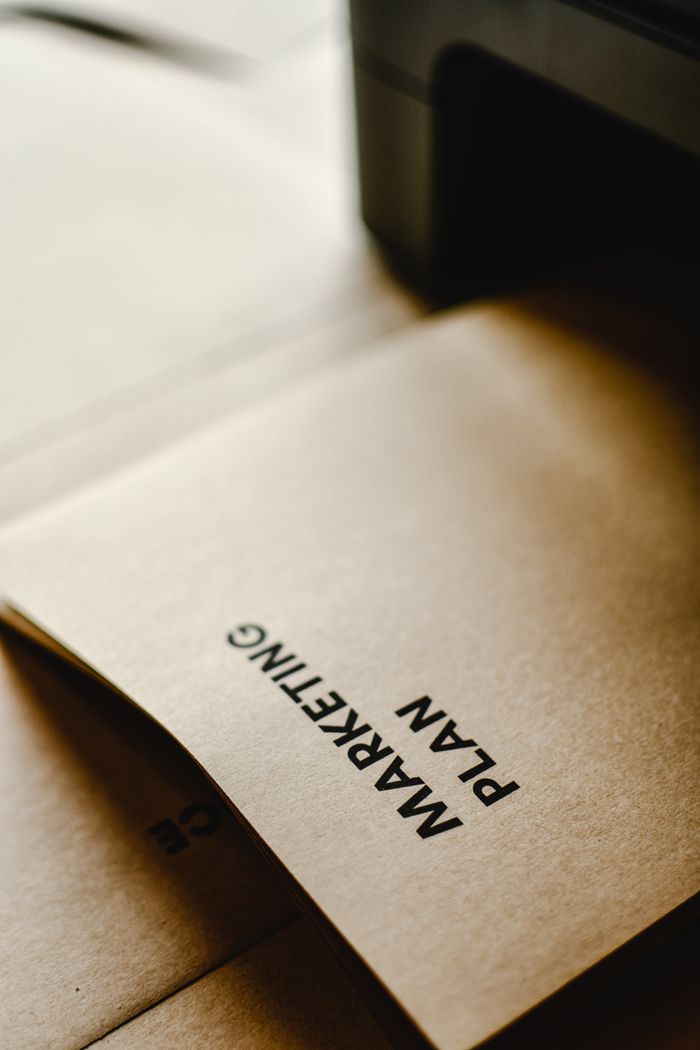 Services Detailed view of the words 'Marketing Plan' printed on brown paper, conceptual and business themed.